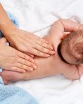 Masseuse massaging 5 months infant