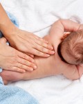 Masseuse massaging 5 months infant