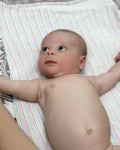 Baby doing exercise on the bed at home