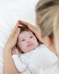 beautiful blond mother, woman massages her baby